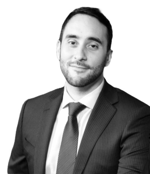 Professional headshot: man in a dark suit and tie, smiling subtly toward the camera.